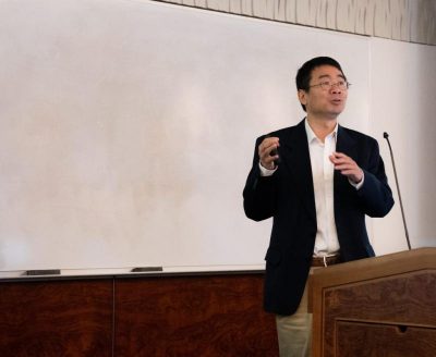 Professor Luyi Sun stands in front of a marker board while presenting at SPARK funding program event